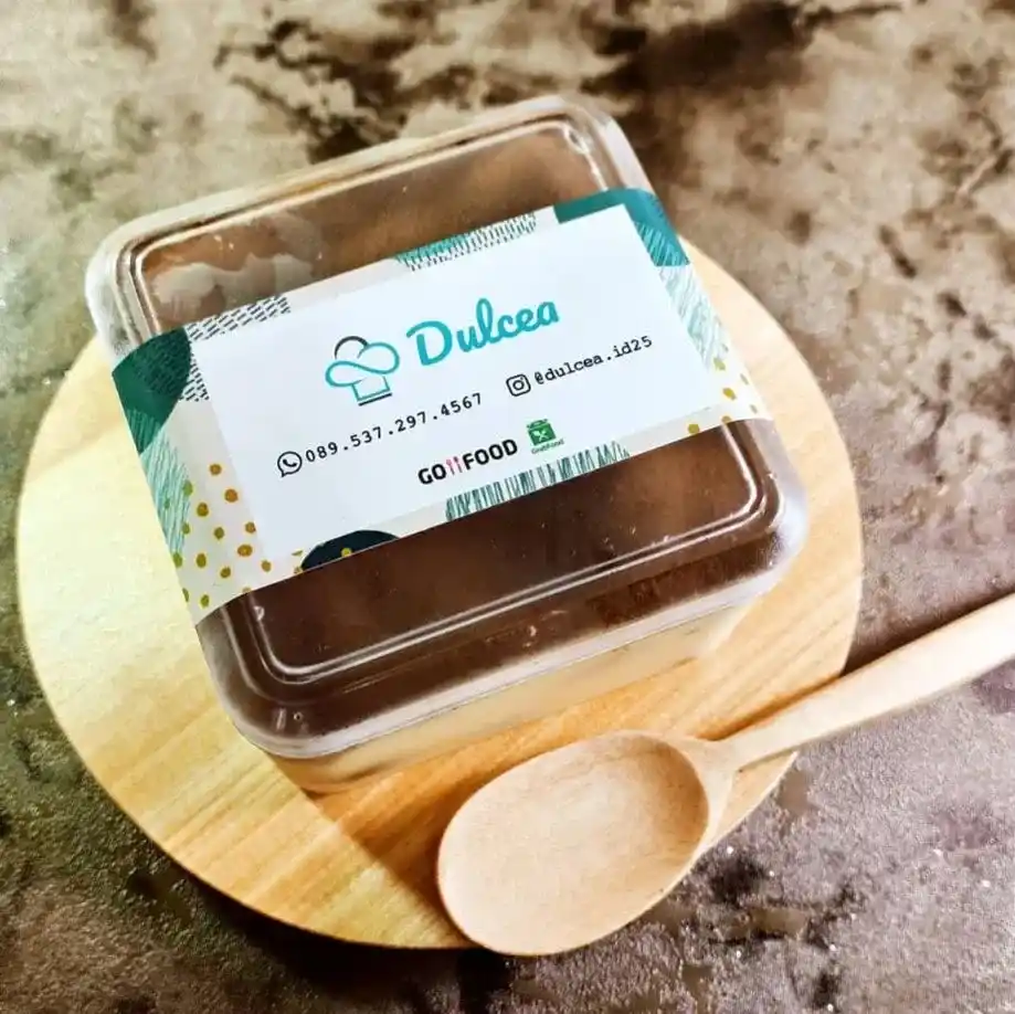 Stiker vinyl Tangerang melingkari wadah plastik bening berisi kue cokelat manis dengan sabuk putih berhias motif hijau